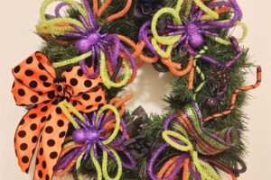 repurpose an old wreath for halloween with mesh tube, purple spiders, and a orange and black bow www.emjaybeedesign.com